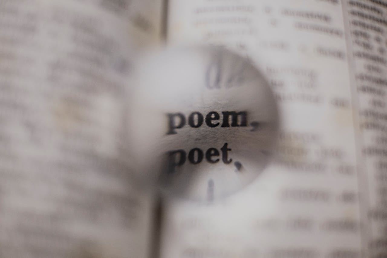 text in a book; the words are fuzzed except the words Poem and Poet which appear magnified in a glass ball or water drop